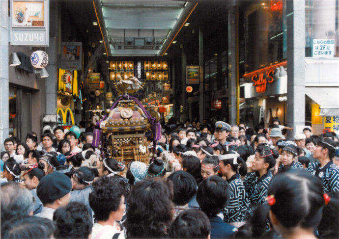 写真：神輿を担ぐ人たちと人だかり