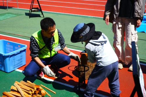 写真：小さい子供が薪割りをする様子