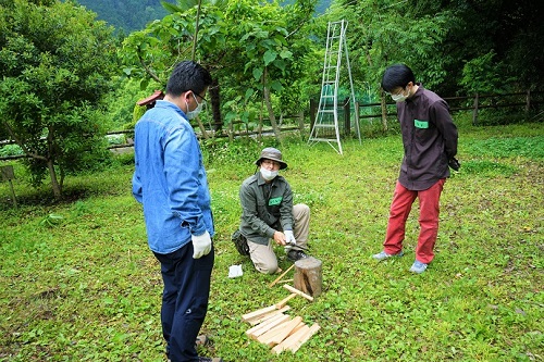 写真：ナタで薪割りをする様子