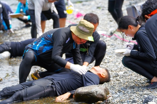 写真：河原で救急法講習をする様子