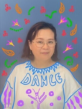 伊藤千枝子プロフィール写真 白い服を着ている 服や背景に草木の絵が描かれている